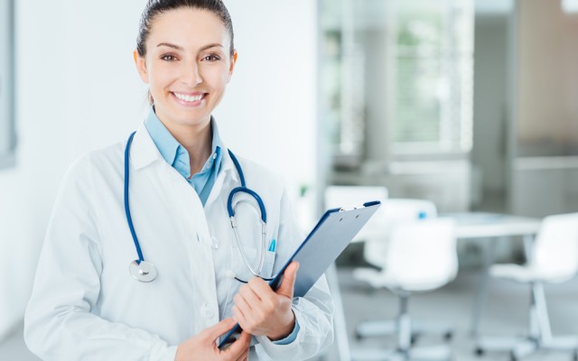 Smiling female doctor holding medical records