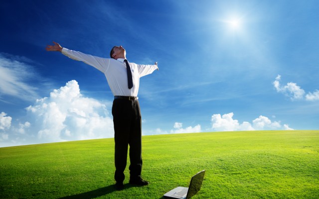 Happy young businessman on spring field