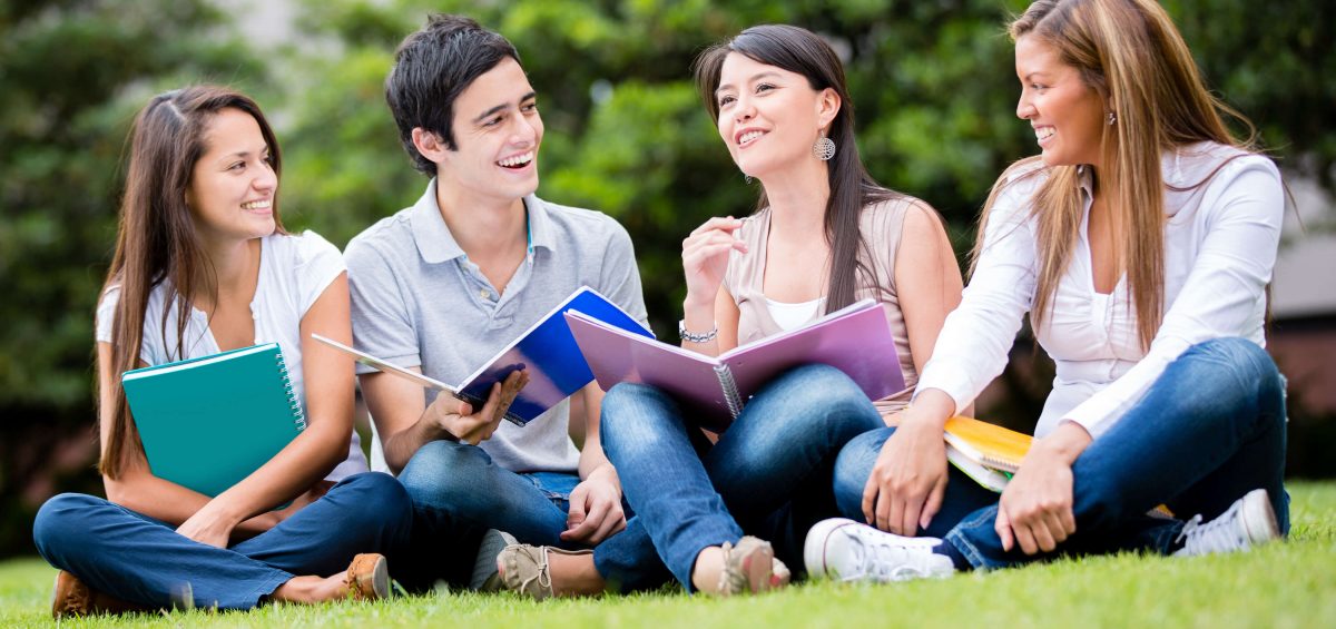 Students-college-happy-laughing-sitting-on-grass